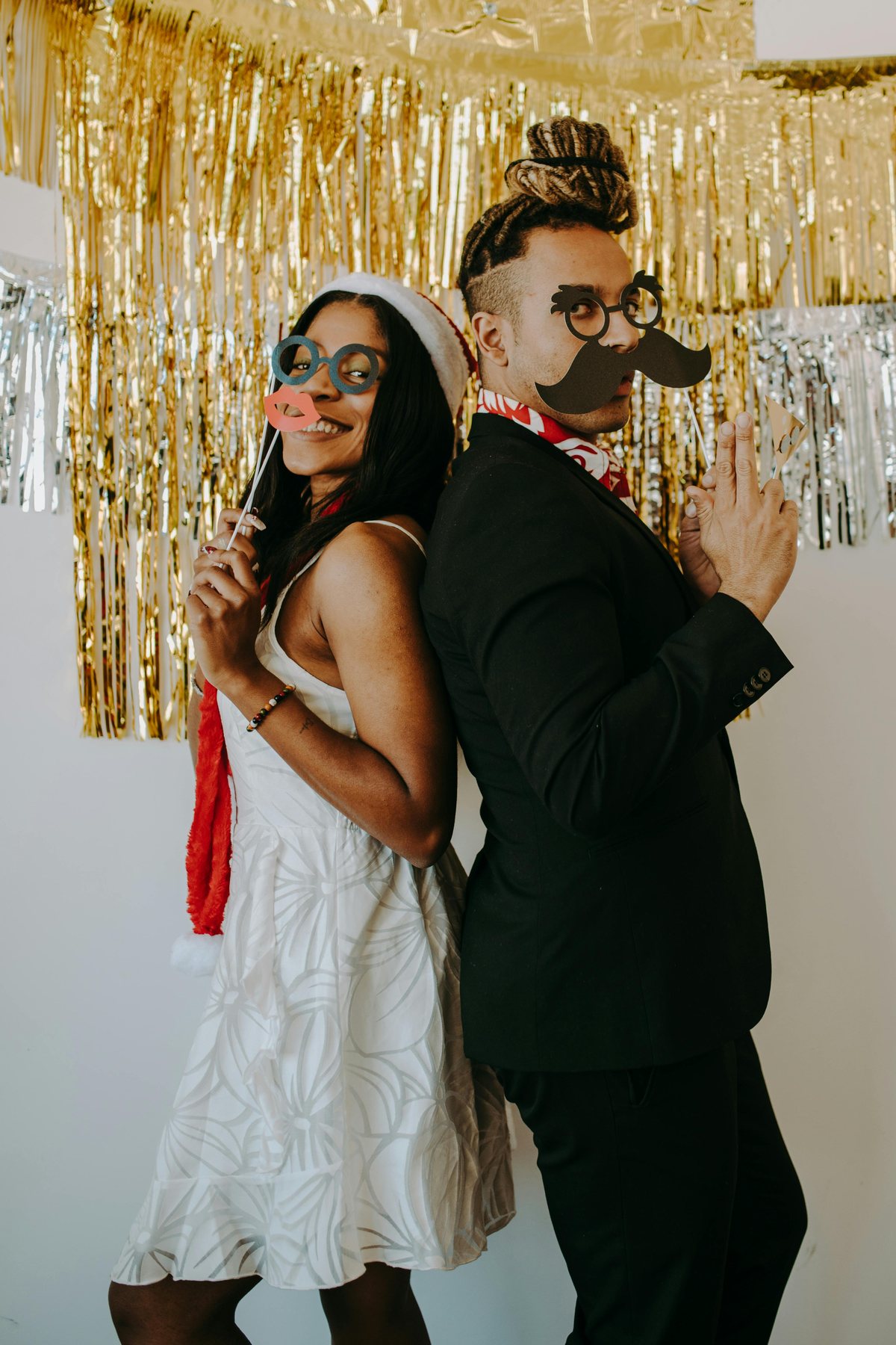 Couple utilisant des accessoires photobooth